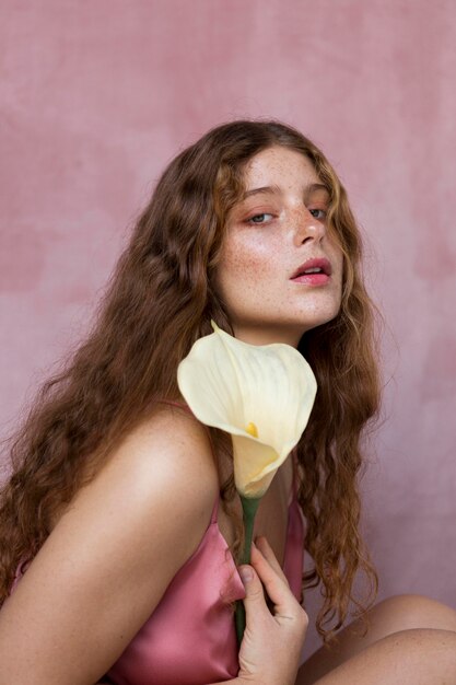 portrait of beautiful freckled woman holding a flower