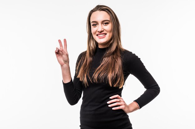 Portrait of a beautiful girl in a dark dress shows victory sign Isolated over white.