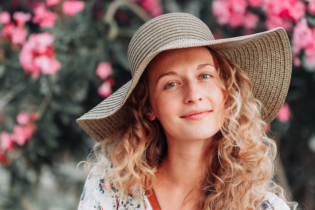 Ritratto di bella ragazza che guarda e che sorride in camicia strutturata bianca durante il giorno.