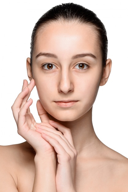 Portrait of beautiful girl stroking her face with healthy skin