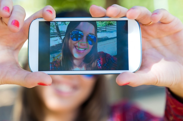 Free photo portrait of beautiful girl taking a selfie with mobile phone in