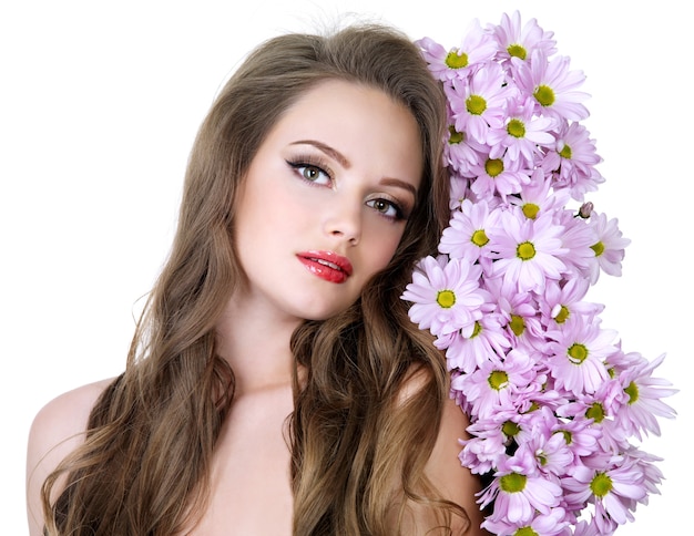 Портрет красивой девушки с красивыми длинными волосами и весенними цветами - белое пространство