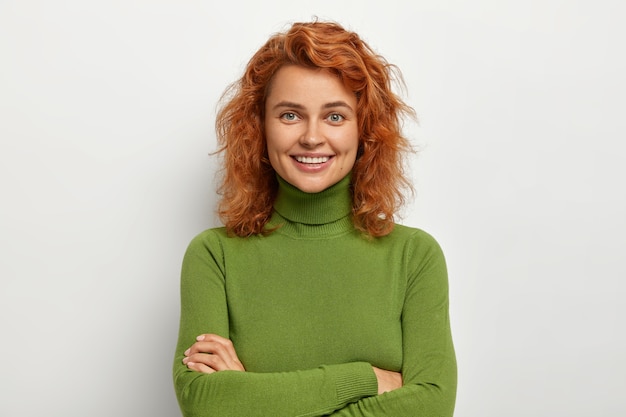 Foto gratuita ritratto di una bella ragazza con i capelli corti allo zenzero, guarda con felice espressione rilassata