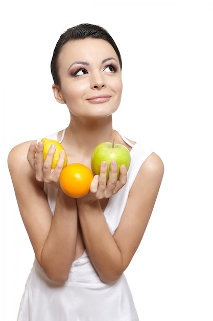 Ritratto di una bella ragazza sorridente felice con frutta limone e mela verde e arancio isolato su bianco