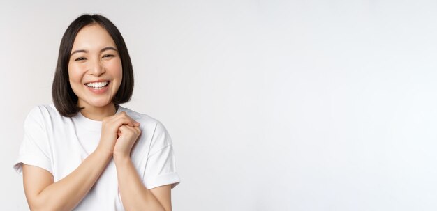 Portrait of beautiful korean woman with healthy white smile laughing and looking happy at camera sta