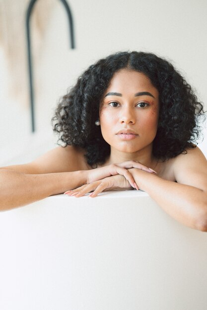 Portrait of beautiful lady at empty room having a bath and looking