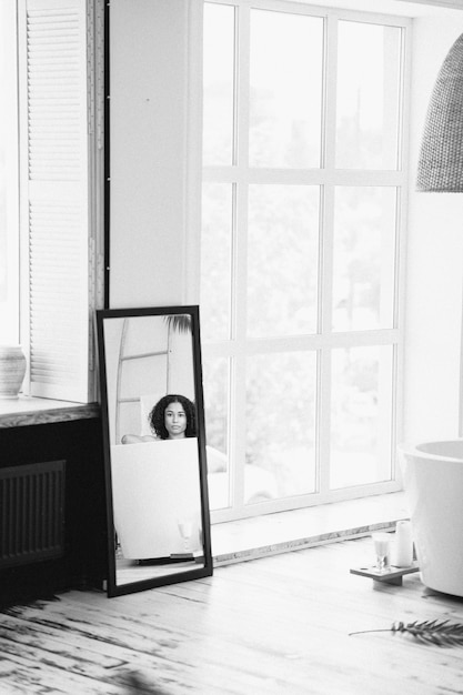 Portrait of beautiful lady having a milk bath view from mirror