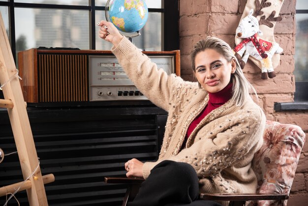 Portrait of beautiful lady holding a world globe up 