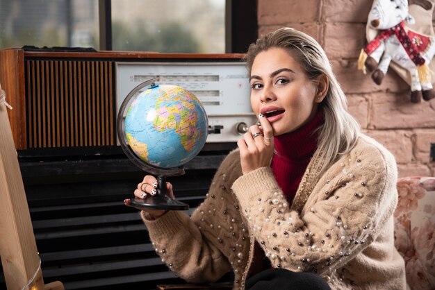 Portrait of beautiful lady holding a world globe 