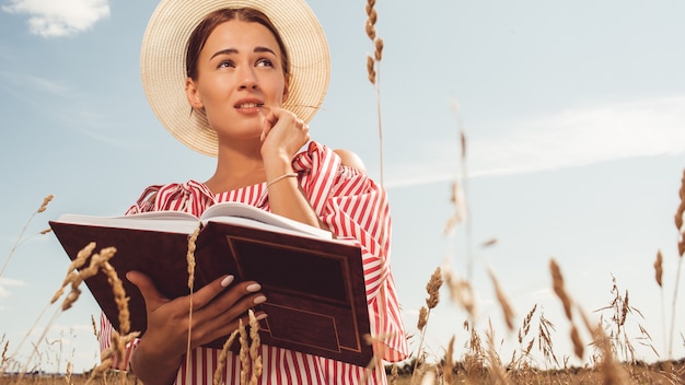 Portrait of a beautiful lady. reads a book in the field. prepare for university entrance.