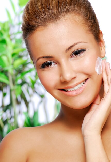 Portrait of beautiful latinos woman applying moisturiser cream