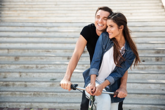 Portrait of a beautiful lovely couple riding on a bicycle