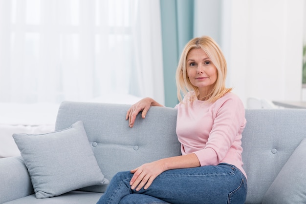 Portrait of beautiful mature woman sitting on the couch