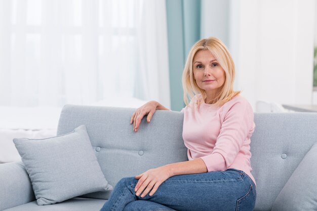 Портрет красивой зрелой женщины, сидя на диване