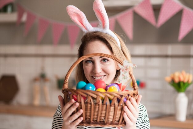 Portrait of beautiful mother holding a basket with eggs