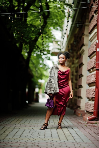 Portrait of a beautiful natural young African woman with afro hair Black model in red silk dress