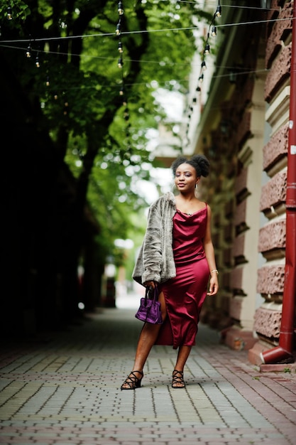 Портрет красивой натуральной молодой африканки с афро-волосами Черная модель в красном шелковом платье