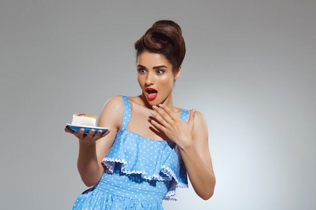 Portrait of beautiful pin-up woman refusing eating cake