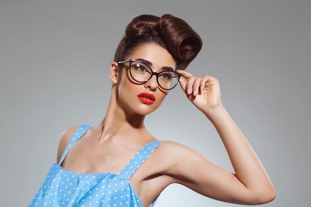 Portrait of beautiful pin-up woman wearing glasses