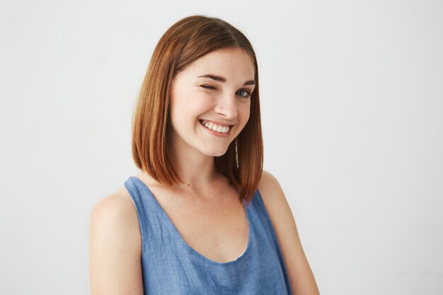 Portrait of beautiful playful brunette girl smiling winking .