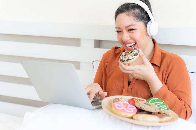 ジャンクフードを食べることの肖像画美しいふっくら若い女性の喜び