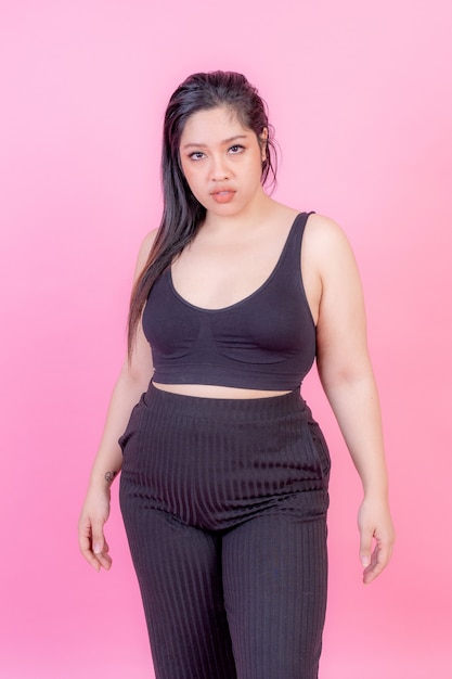 Portrait beautiful plump young woman smiling on pink