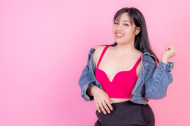 Portrait beautiful plump young woman smiling on pink