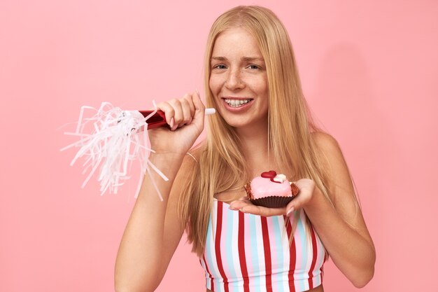 Portrait of beautiful pretty teenage girl with freckles and braces on her teeth enjoying birthday party