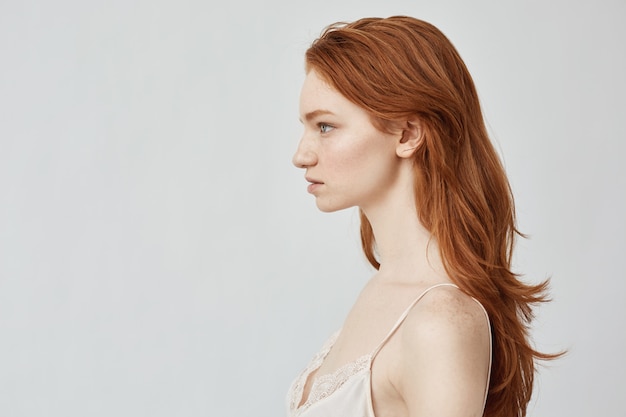 Portrait of beautiful redhead girl posing in profile.