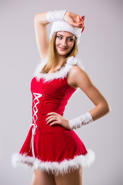 Portrait of beautiful sexy woman wearing like santa claus dancing isolated on white background