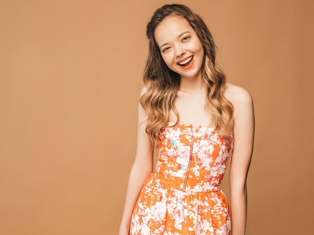 Portrait of beautiful smiling cute model with pink lips. Girl in summer colorful dress. Model posing