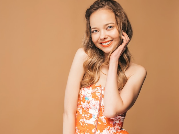 Portrait of beautiful smiling cute model with pink lips. Girl in summer colorful dress. Model posing