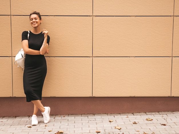 Portrait of beautiful smiling model dressed in summer clothes. Trendy girl posing in the street. Funny and positive woman having fun