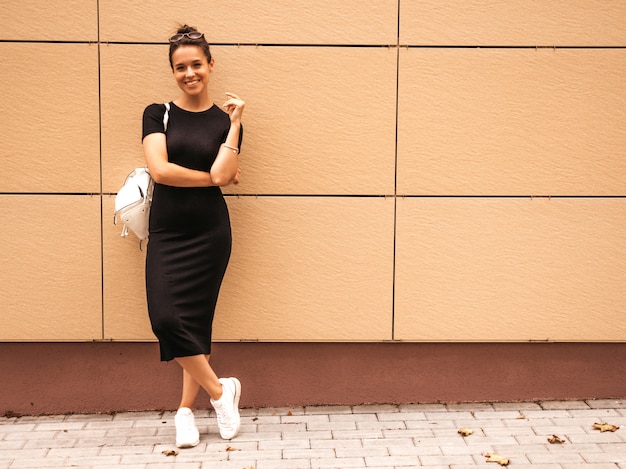 Portrait of beautiful smiling model dressed in summer clothes. Trendy girl posing in the street. Funny and positive woman having fun