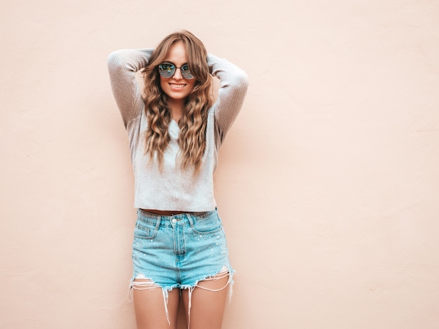 Portrait of beautiful smiling model dressed in summer hipster jeans shorts clothes