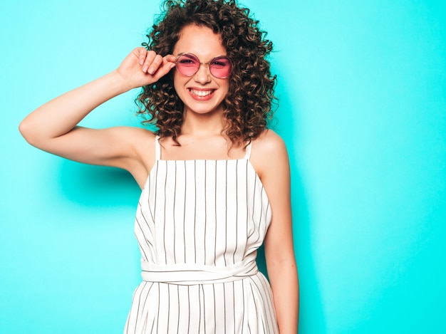 Portrait of beautiful smiling model with afro curls hairstyle dressed in summer hipster clothes.Trendy funny and positive woman