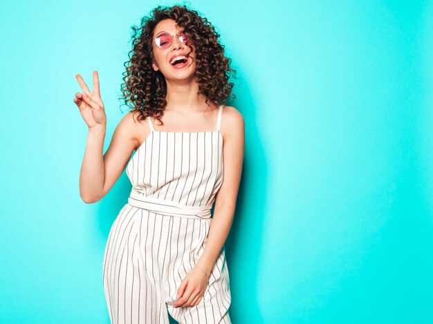 Portrait of beautiful smiling model with afro curls hairstyle dressed in summer hipster clothes.Trendy funny and positive woman