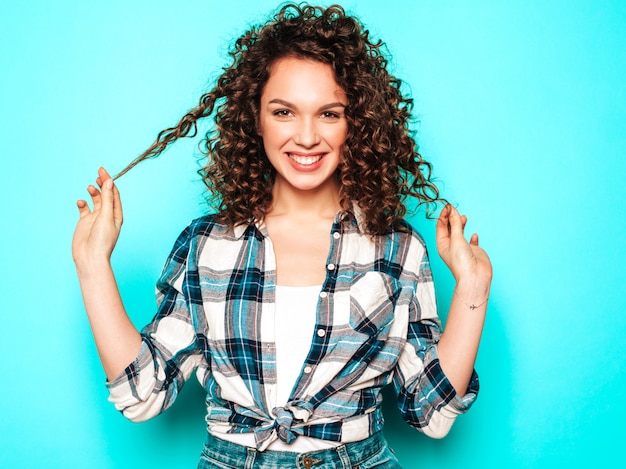 Foto gratuita il ritratto di bello modello sorridente con l'acconciatura dei riccioli di afro si è vestito in vestiti dei pantaloni a vita bassa dell'estate. donna divertente e positiva alla moda