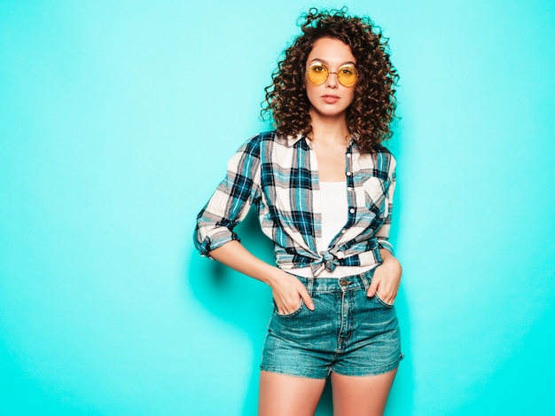 Portrait of beautiful smiling model with afro curls hairstyle dressed in summer hipster clothes.Trendy funny and positive woman