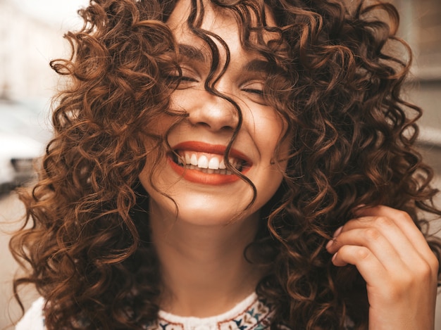 Free photo portrait of beautiful smiling model with afro curls hairstyle.