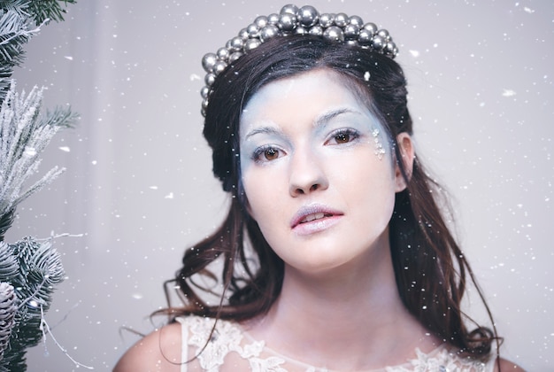 Портрет красивой снежной королевы среди падающего снега