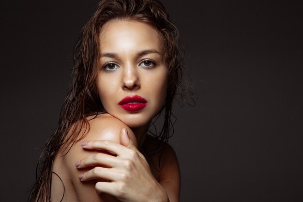 Portrait of beautiful stylish woman isolated on dark studio background