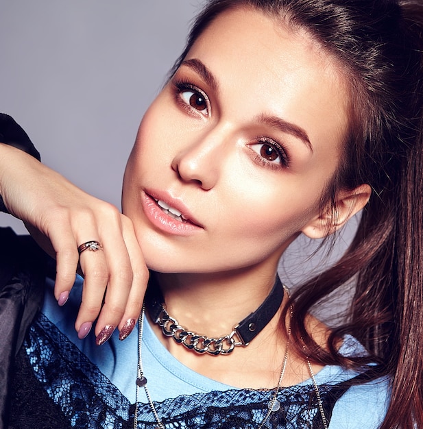 Portrait of beautiful stylish young woman touching her chin