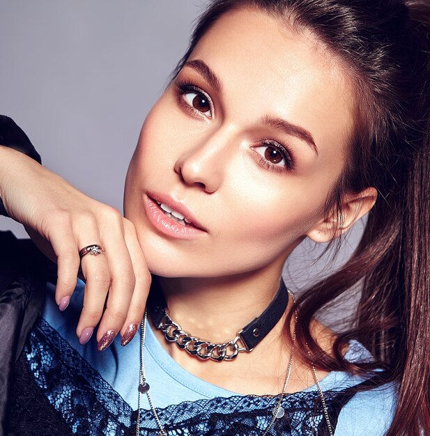 Portrait of beautiful stylish young woman touching her chin