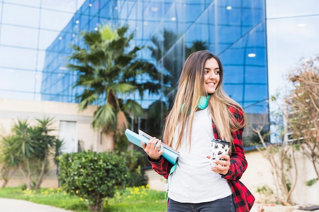 Foto gratuita ritratto di una bella ragazza adolescente in piedi al campus