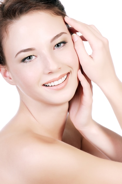 Free photo a portrait of a beautiful teenage woman with a clear white skin, on a white wall.