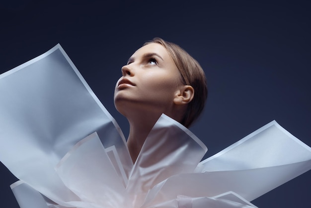 Portrait of beautiful tender young woman posing isolated over dark blue background Female aesthetics