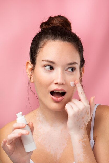 Portrait of a beautiful woman applying moisturizer