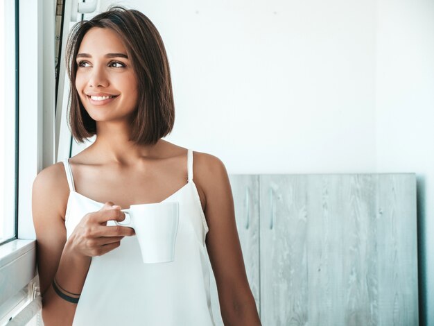 Ritratto di bella donna vestita di pigiama bianco