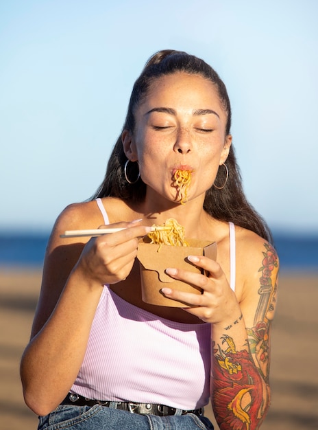 Portrait of beautiful woman eating street food